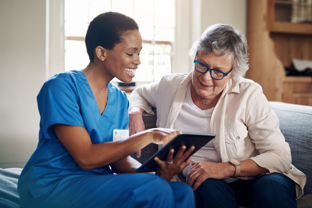 Nurse showing an elderly woman an Ipad