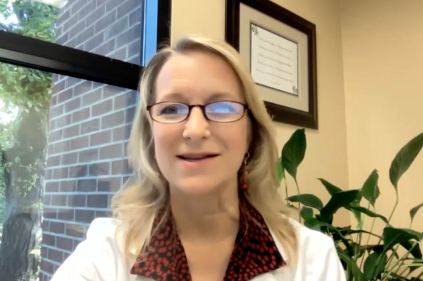 A women in a white coat talking